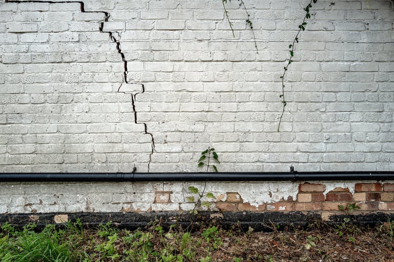 Bad building subsidence seen on an old English cottage with broken bricks
