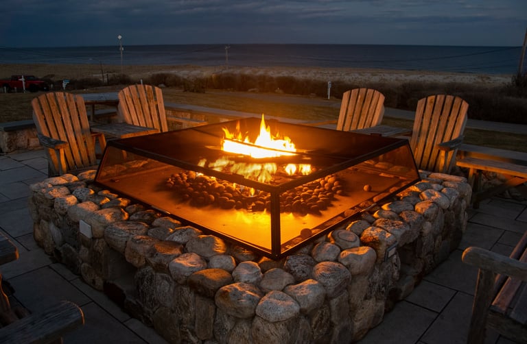 Adirondack Chairs around a Fire Place Near the Beach