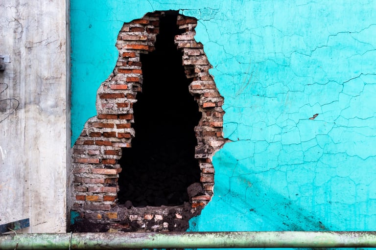 Weathered cyan wall with decaying brickwork