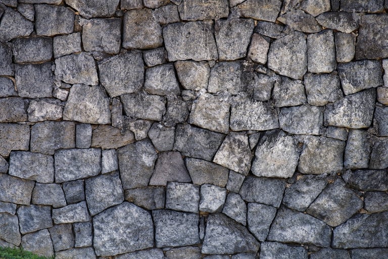 Rustic stone walls in lush greenery with moss and lichen textures