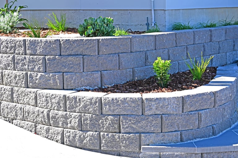 Curved concrete block wall with a garden