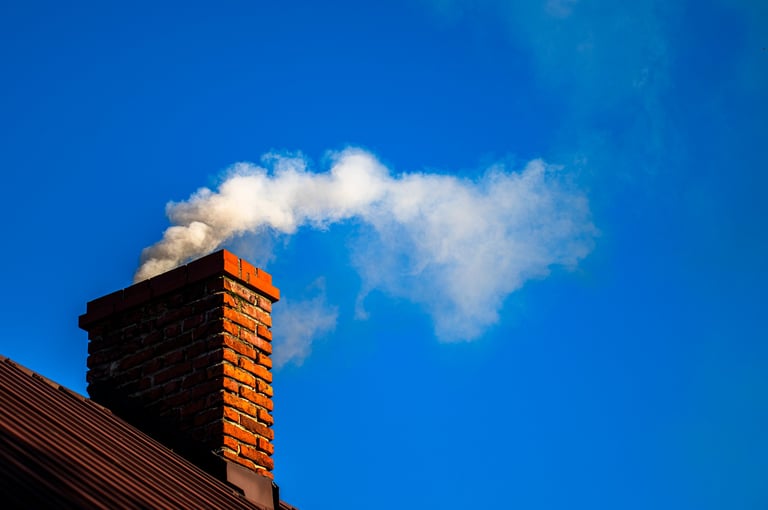 Smoke from the chimney of a single-family house