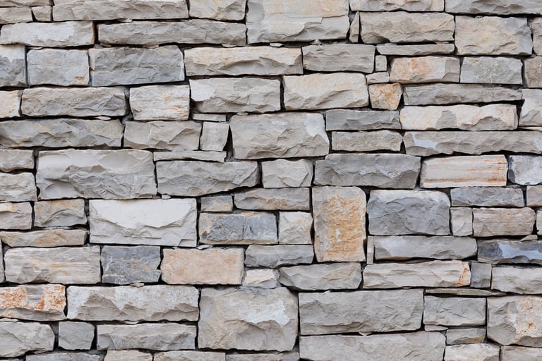 Rough cut light gray stacked stone wall texture