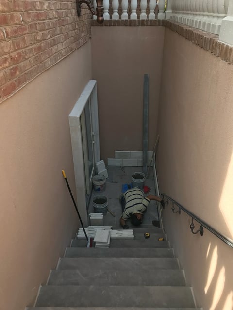 Basement stairwell with HVAC equipment, ductwork, and various mechanical components on concrete floor